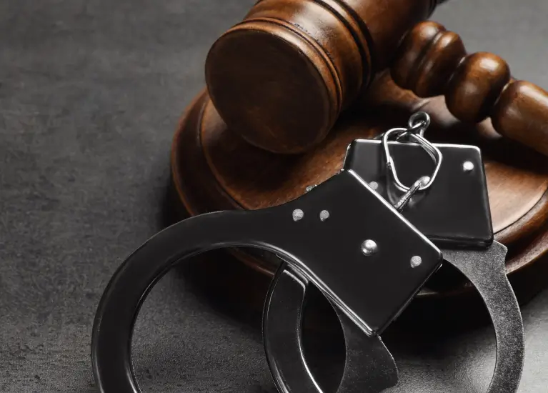 A gavel and handcuffs on a table